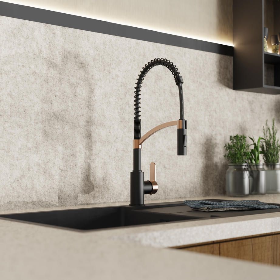 Wasserwerk black and rose gold spring kitchen faucet mounted on a sink